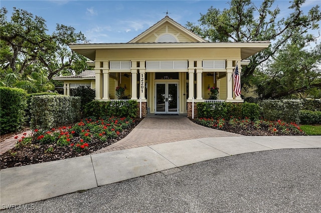 view of front of home with covered porch and french doors