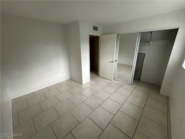 unfurnished bedroom with light tile patterned floors and a closet