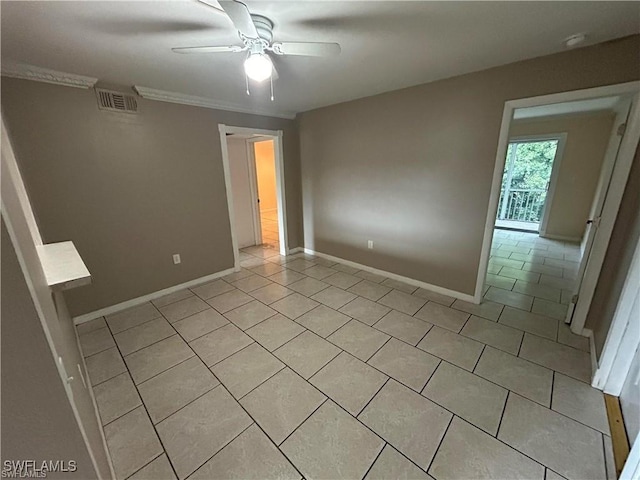 tiled empty room featuring ceiling fan and crown molding