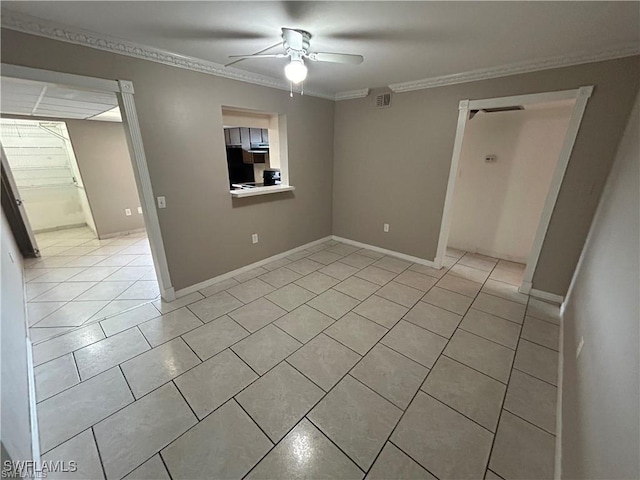 tiled empty room featuring ceiling fan and crown molding