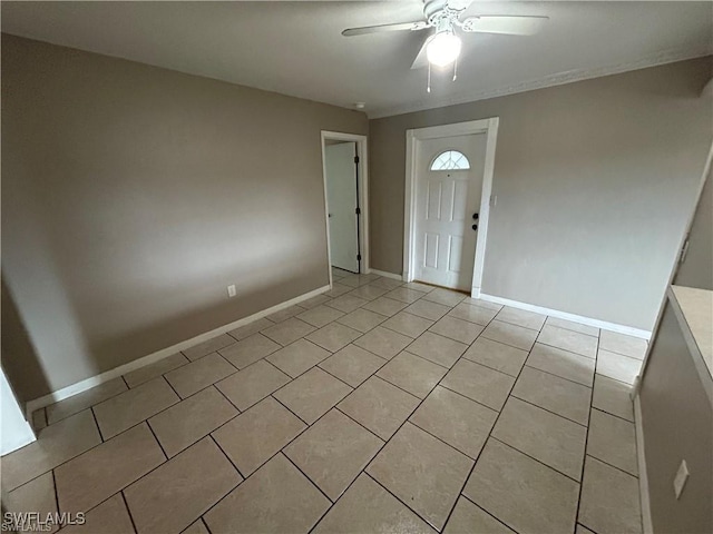 foyer entrance with ceiling fan and light tile patterned flooring