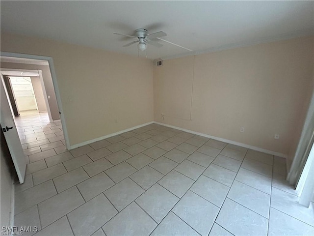 tiled spare room featuring ceiling fan