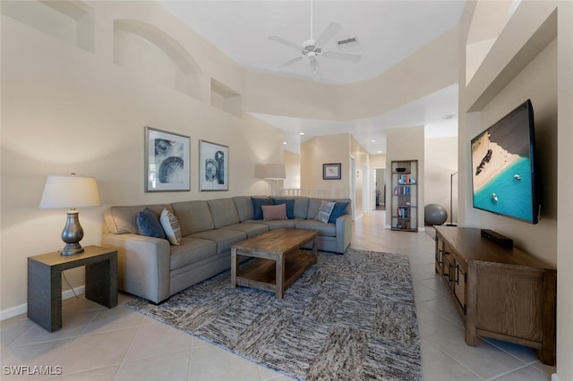 living room featuring ceiling fan, a towering ceiling, and light tile patterned floors