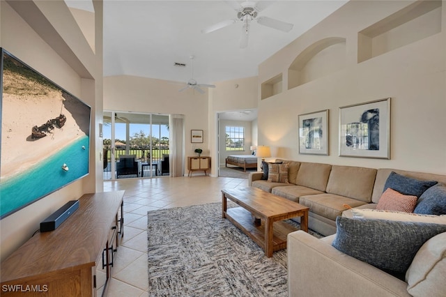 living room featuring light tile patterned floors, a towering ceiling, and ceiling fan