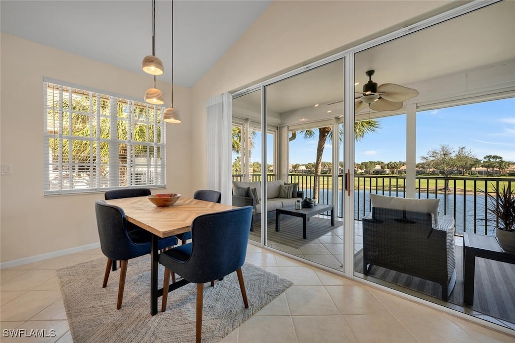 dining space with ceiling fan, light tile patterned flooring, and vaulted ceiling