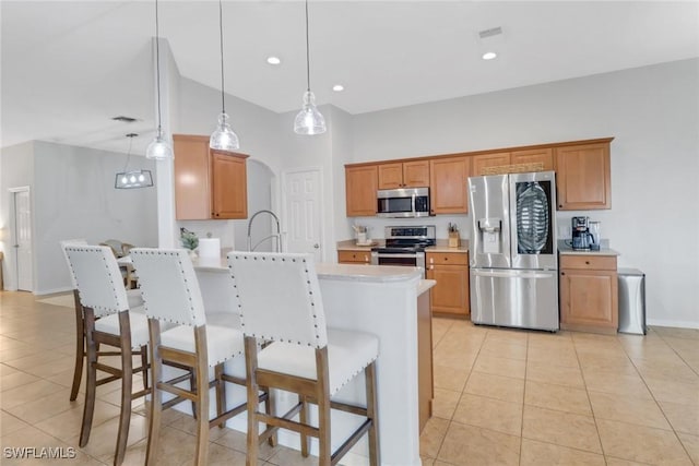 kitchen featuring sink, appliances with stainless steel finishes, decorative light fixtures, light tile patterned flooring, and kitchen peninsula