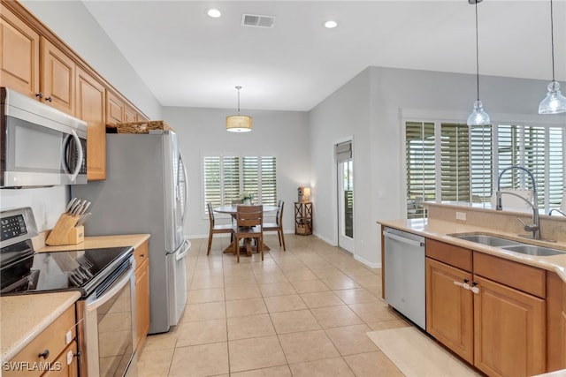 kitchen with light tile patterned floors, stainless steel appliances, hanging light fixtures, and sink