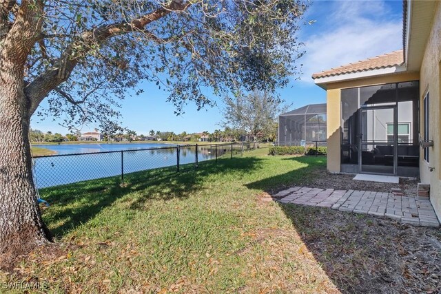 view of yard with a water view and a lanai