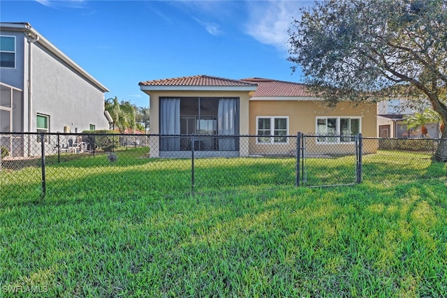 back of property featuring a lawn and a sunroom