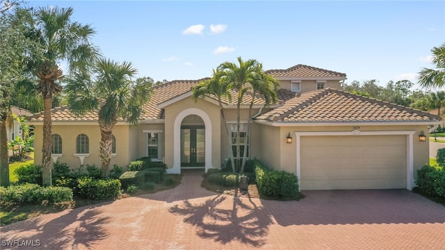 mediterranean / spanish-style home featuring a garage and french doors