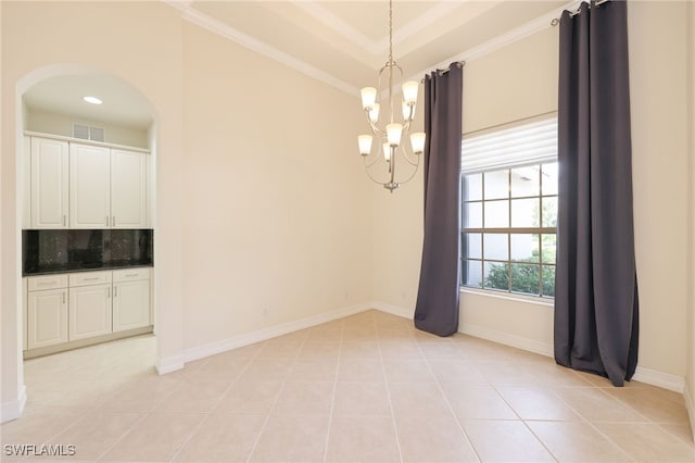 tiled empty room featuring a raised ceiling, crown molding, and a notable chandelier