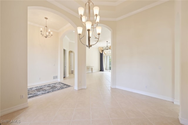 spare room with light tile patterned floors, a tray ceiling, crown molding, and a chandelier