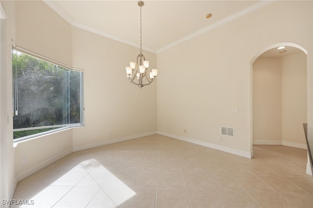 tiled spare room with a notable chandelier and ornamental molding