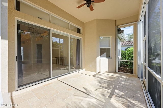 unfurnished sunroom with ceiling fan