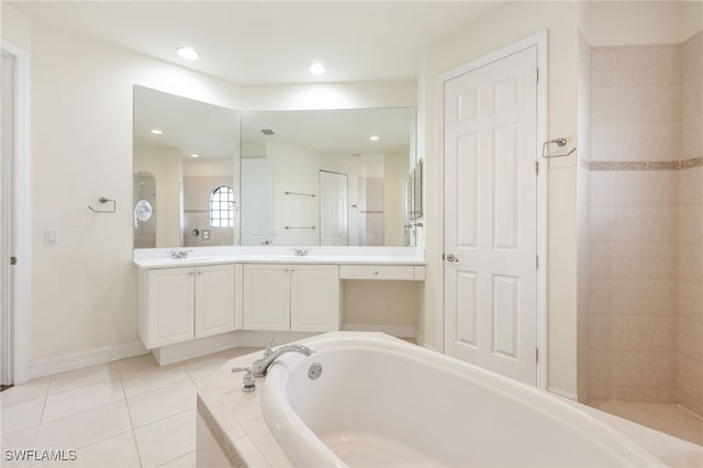 bathroom with tiled tub, tile patterned floors, and vanity