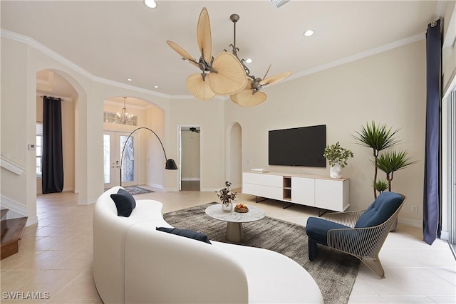 living room featuring light tile patterned flooring, ceiling fan with notable chandelier, and ornamental molding