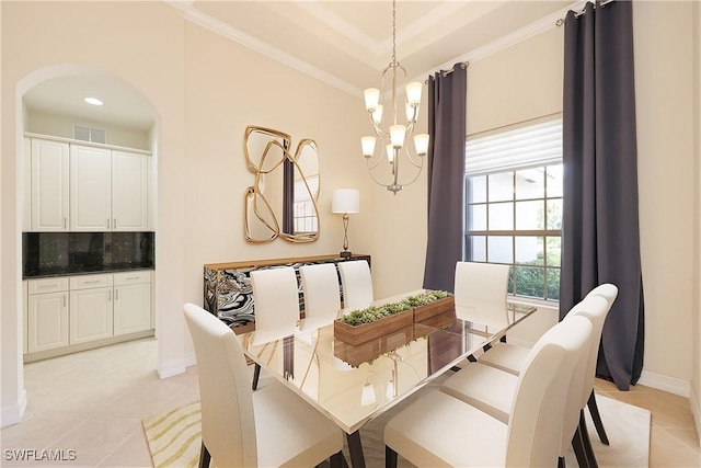 tiled dining space featuring an inviting chandelier and ornamental molding