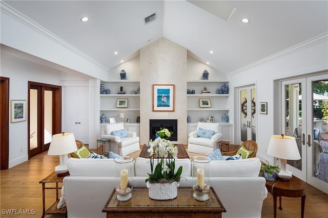 living area with light wood-style floors, french doors, visible vents, and built in shelves