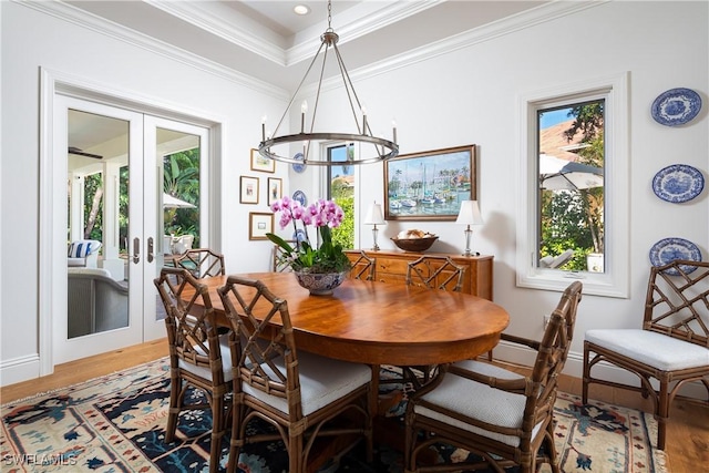 dining room with light wood-type flooring, baseboards, crown molding, and french doors