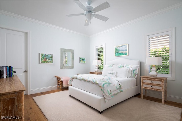 bedroom featuring ornamental molding, a ceiling fan, baseboards, and wood finished floors