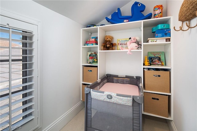 bedroom with lofted ceiling and baseboards