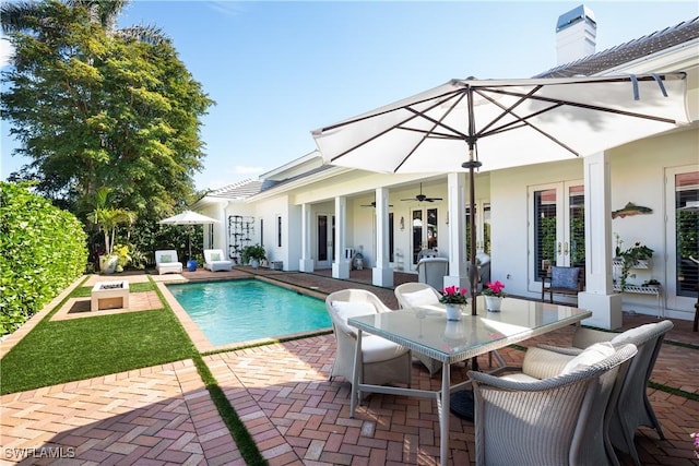 outdoor pool featuring outdoor dining area, ceiling fan, french doors, and a patio