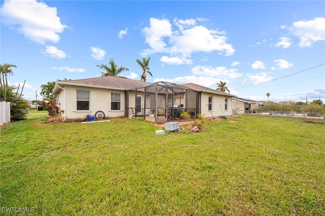 back of property with a yard and a lanai