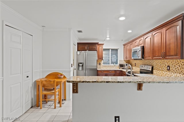 kitchen featuring stainless steel appliances, light stone countertops, a kitchen breakfast bar, and decorative backsplash