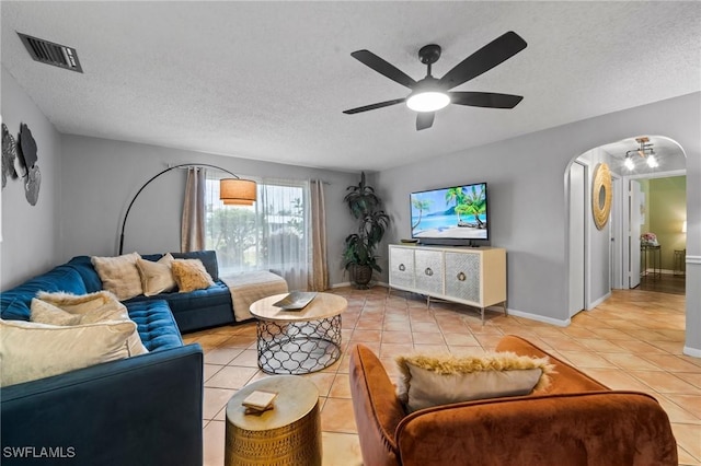 tiled living room featuring ceiling fan and a textured ceiling