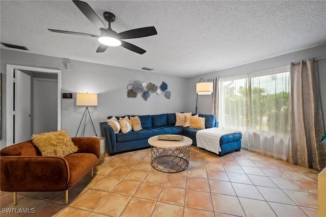 living room with light tile patterned floors, a textured ceiling, and ceiling fan