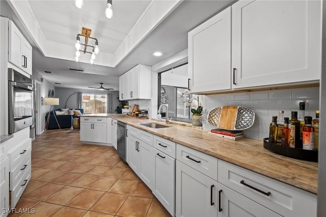 kitchen featuring white cabinets, appliances with stainless steel finishes, tasteful backsplash, and sink