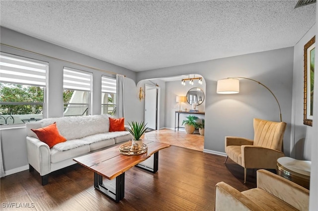 living room with dark wood-type flooring and a textured ceiling