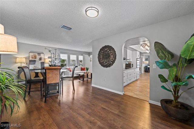 dining area featuring a textured ceiling and dark hardwood / wood-style floors