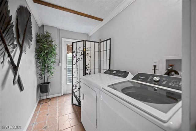 washroom with light tile patterned floors, a textured ceiling, ornamental molding, and washing machine and clothes dryer