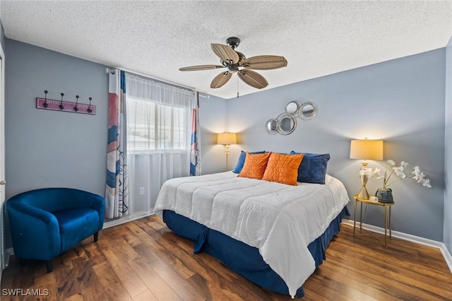 bedroom with a textured ceiling, dark hardwood / wood-style flooring, and ceiling fan