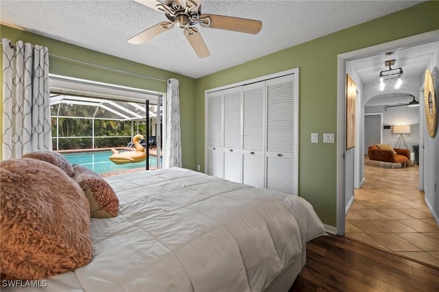 bedroom featuring ceiling fan, tile patterned flooring, a textured ceiling, access to outside, and a closet