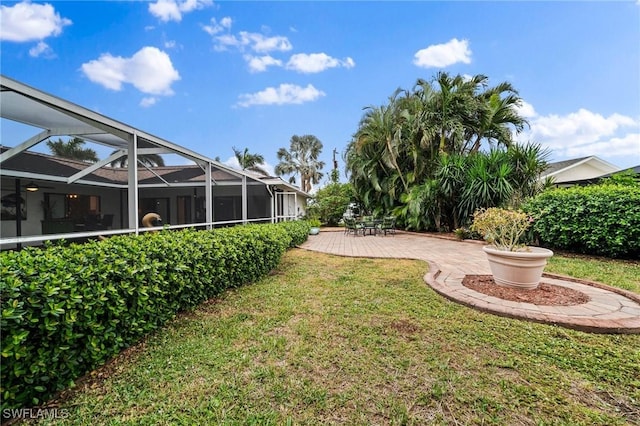 view of yard with glass enclosure and a patio