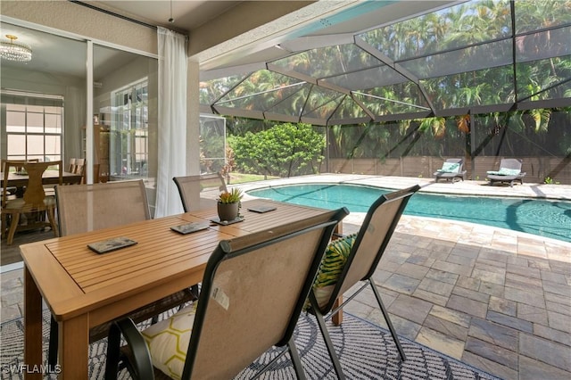 view of swimming pool featuring glass enclosure and a patio