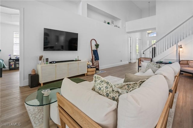 living room with hardwood / wood-style floors and a high ceiling