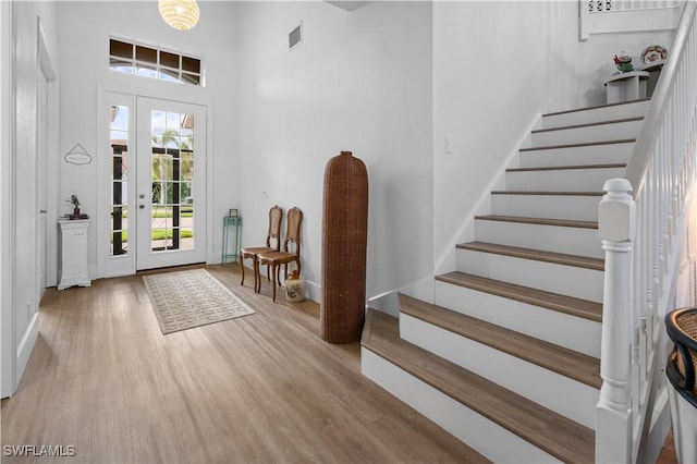 entryway with a towering ceiling and light hardwood / wood-style flooring