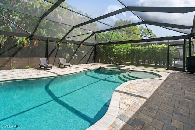 view of pool featuring an in ground hot tub, glass enclosure, and a patio area