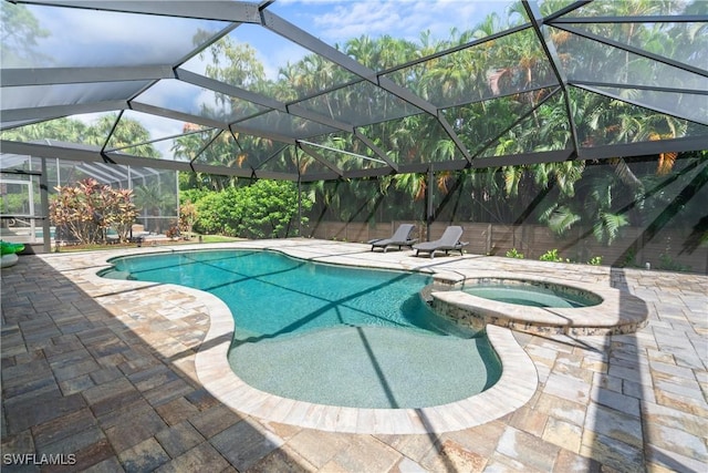 view of swimming pool with a lanai, a patio area, and an in ground hot tub