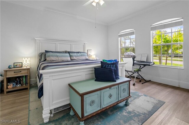 bedroom with hardwood / wood-style flooring, ceiling fan, and ornamental molding