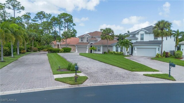 view of front of property with a garage, central air condition unit, and a front lawn