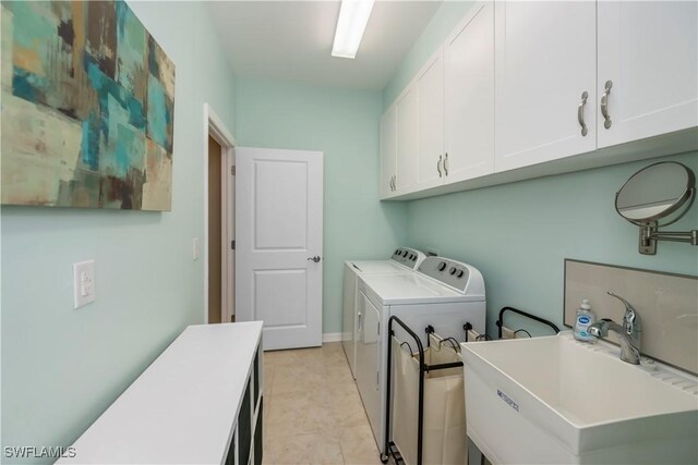 washroom featuring cabinets, sink, light tile patterned floors, and separate washer and dryer