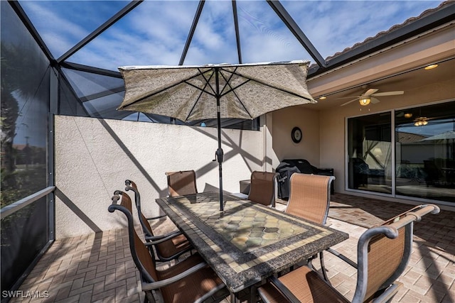 view of patio / terrace featuring ceiling fan and a lanai