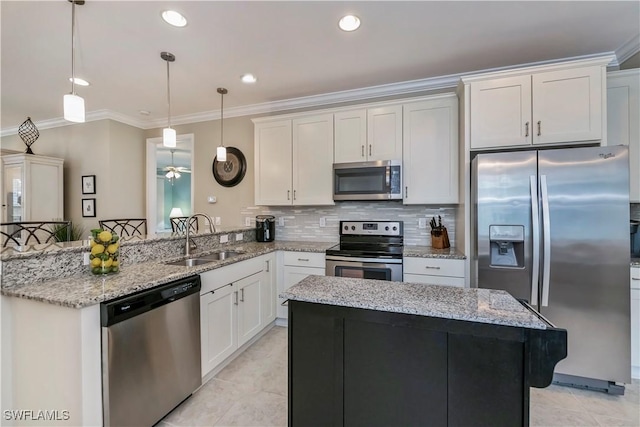 kitchen with kitchen peninsula, appliances with stainless steel finishes, hanging light fixtures, crown molding, and sink