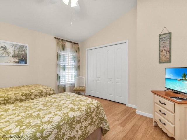 bedroom with ceiling fan, a closet, vaulted ceiling, and light hardwood / wood-style flooring