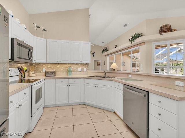 kitchen with sink, decorative backsplash, light tile patterned floors, white cabinetry, and stainless steel appliances