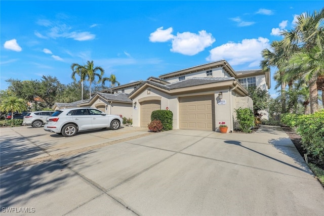 view of front of house featuring concrete driveway, an attached garage, and stucco siding